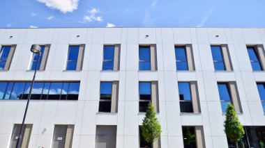 Office building with white aluminum composite panels. Facade wall made of glass and metal. Abstract modern business architecture.