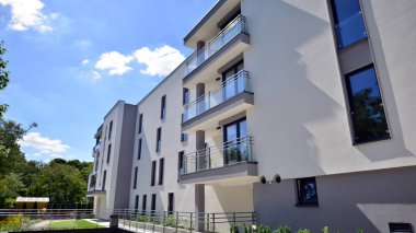 Modern lüks konut dairesi. Güneşli bir günde modern apartman binası. Mavi gökyüzü olan bir apartman. Modern bir apartmanın cephesi.