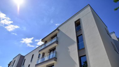 Modern lüks konut dairesi. Güneşli bir günde modern apartman binası. Mavi gökyüzü olan bir apartman. Modern bir apartmanın cephesi.