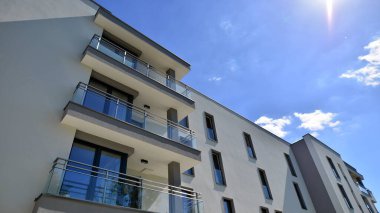 Modern lüks konut dairesi. Güneşli bir günde modern apartman binası. Mavi gökyüzü olan bir apartman. Modern bir apartmanın cephesi.