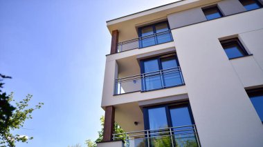 Modern lüks konut dairesi. Güneşli bir günde modern apartman binası. Mavi gökyüzü olan bir apartman. Modern bir apartmanın cephesi.