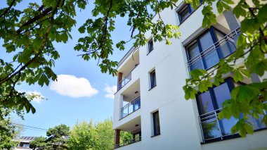 Modern lüks konut dairesi. Güneşli bir günde modern apartman binası. Mavi gökyüzü olan bir apartman. Modern bir apartmanın cephesi.