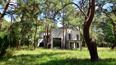 Terk edilmiş, modern, yalnız aile evi ormanda duruyor..