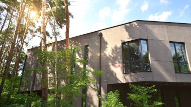 A modern office building among the trees in calm green neighborhood.