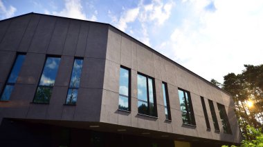 A modern office building among the trees in calm green neighborhood.