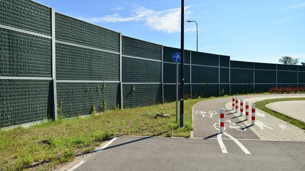 Reducing of noise and sound pollution made by transportation. Narrow road and acoustical barrier.