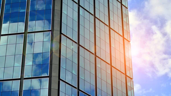 Modern glass facade against blue sky. Bottom view of a  building in the business district. Low angle view of the glass facade of an office building.