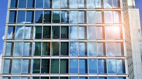 Modern glass facade against blue sky. Bottom view of a  building in the business district. Low angle view of the glass facade of an office building.