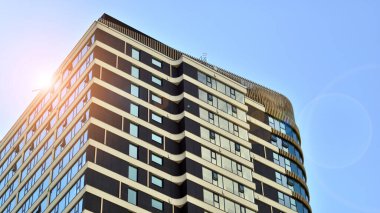 Çok katlı, modern bir apartmanın dış cephesi, pencereleri ve balkonları..