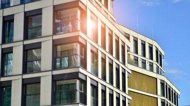 Çok katlı, modern bir apartmanın dış cephesi, pencereleri ve balkonları..