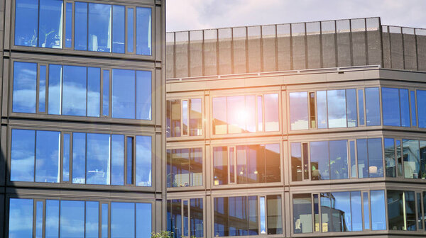 Architecture details. Modern glass building facade in sunny day. Business background.