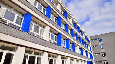 Modern şehir geometrisinin bir parçası. Çelik ve camdan yapılmış duvar ofis binası. Parlak güneşli bir gün Mavi gökyüzünde güneş ışığı. 