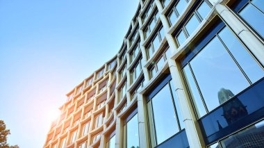 Yansıtıcı camlarla kaplı modern bir binanın cam kaplamalı dış cephesinin soyut yakın çekimi. Mimari soyut arkaplan. Cam duvar ve ön cephe ayrıntıları.