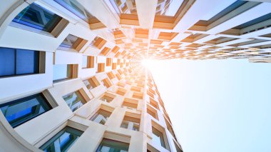 Mavi gökyüzüne karşı modern gökdelenin alt manzarası. Şehir merkezindeki iş binasına bakıyorum..