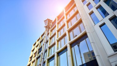 Yansıtıcı camlarla kaplı modern bir binanın cam kaplamalı dış cephesinin soyut yakın çekimi. Mimari soyut arkaplan. Cam duvar ve ön cephe ayrıntıları.