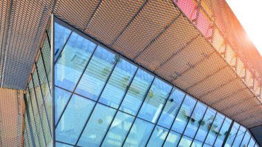 Yansıtıcı camlarla kaplı modern bir binanın cam kaplamalı dış cephesinin soyut yakın çekimi. Mimari soyut arkaplan. Cam duvar ve ön cephe ayrıntıları.