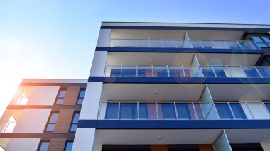 Modern lüks konut dairesi. Güneşli bir günde modern apartman binası. Mavi gökyüzü olan bir apartman. Modern bir apartmanın cephesi.