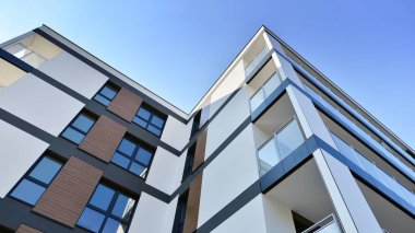 Modern lüks konut dairesi. Güneşli bir günde modern apartman binası. Mavi gökyüzü olan bir apartman. Modern bir apartmanın cephesi.