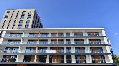 Modern lüks konut dairesi. Güneşli bir günde modern apartman binası. Mavi gökyüzü olan bir apartman. Modern bir apartmanın cephesi.