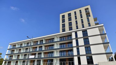 Modern lüks konut dairesi. Güneşli bir günde modern apartman binası. Mavi gökyüzü olan bir apartman. Modern bir apartmanın cephesi.