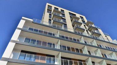 Modern lüks konut dairesi. Güneşli bir günde modern apartman binası. Mavi gökyüzü olan bir apartman. Modern bir apartmanın cephesi.