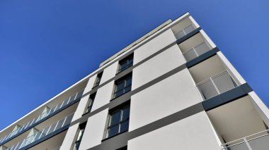 Modern lüks konut dairesi. Güneşli bir günde modern apartman binası. Mavi gökyüzü olan bir apartman. Modern bir apartmanın cephesi.