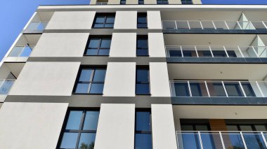 Modern lüks konut dairesi. Güneşli bir günde modern apartman binası. Mavi gökyüzü olan bir apartman. Modern bir apartmanın cephesi.