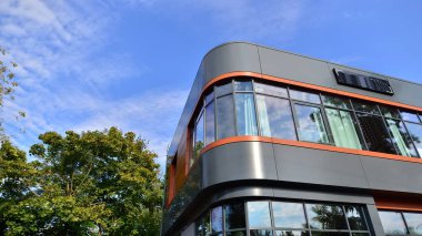 Taze yeşil ağaçlar ve ofis binası, iş konsepti. Modern şehir konseptinde yankı oluşturma.  