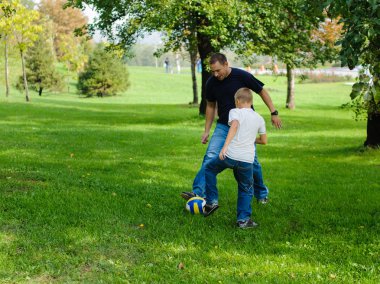 genç çocuk babasıyla birlikte futbol oynamaya