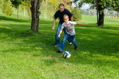 genç çocuk babasıyla birlikte futbol oynamaya