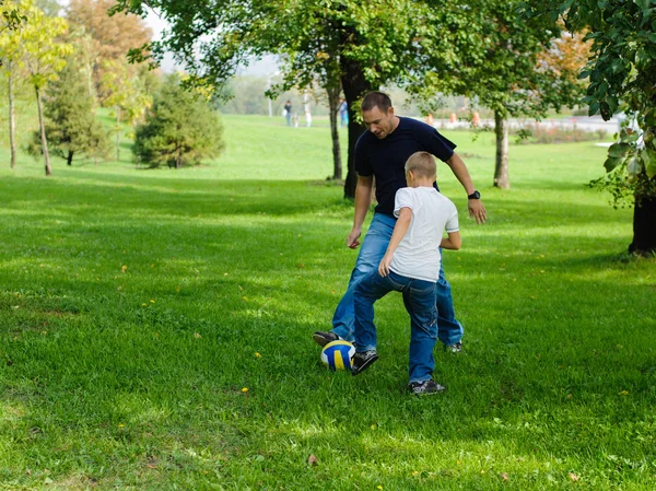 Jeune garçon jouant au football avec son père — Photo