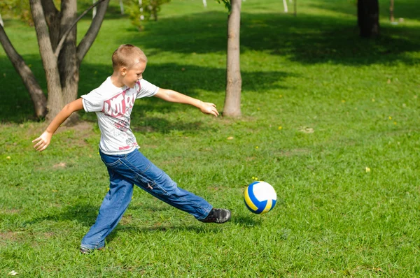 Jeune garçon jouant au football en plein air — Photo