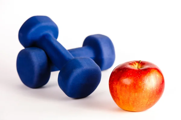 Blue dumbbells and red apple — Stock Photo, Image