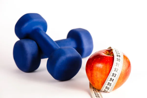 Blue dumbbells and red apple with measure tape — Stock Photo, Image