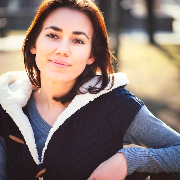 Portret van een jong meisje, zittend op een bankje — Stockfoto