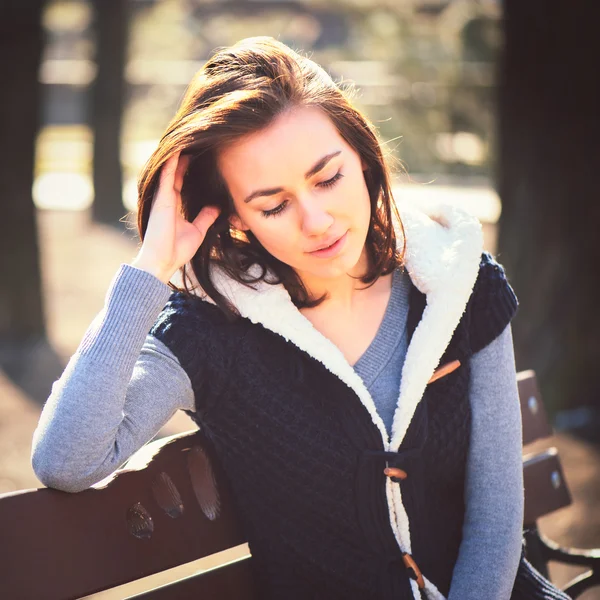 Portrait of young girl sitting on a bench — Stock Photo, Image