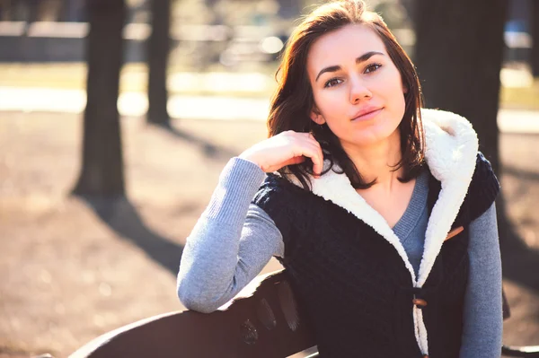 Portrait of young girl sitting on a bench — Stock Photo, Image