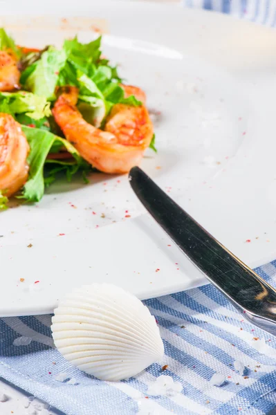 Shrimps on plate and seashell — Stock Photo, Image