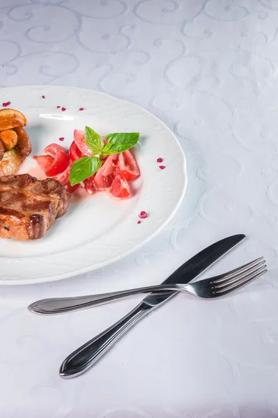 Carne grelhada com salada de tomate Fotos De Bancos De Imagens Sem Royalties