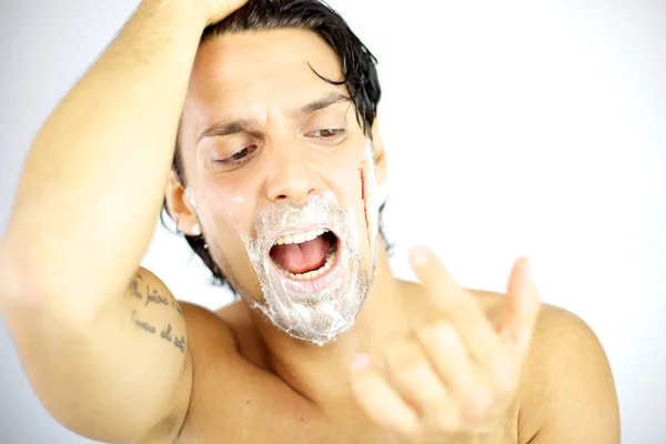Handsome man shouting with blood on his face after shaving — Stock Photo, Image