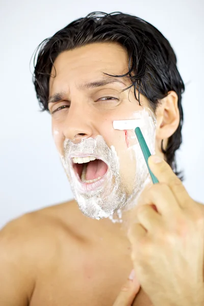 Homem gritando enquanto barbeando corte com lâmina — Fotografia de Stock