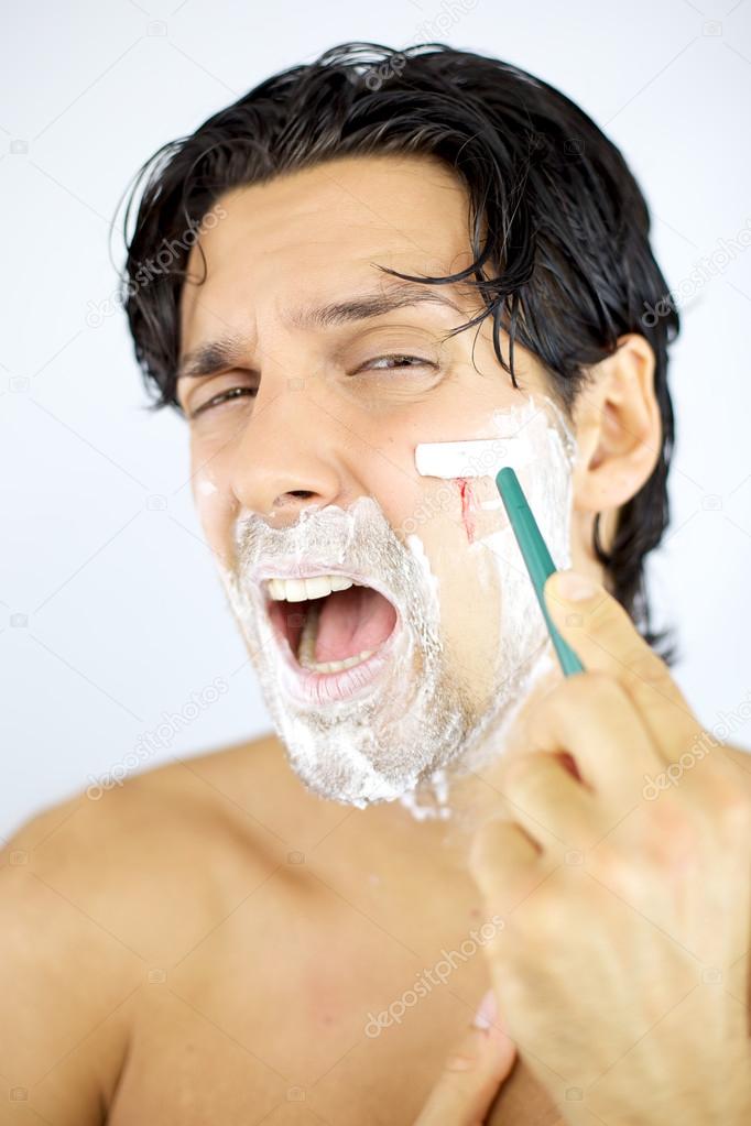 Man shouting while shaving cutting with blade