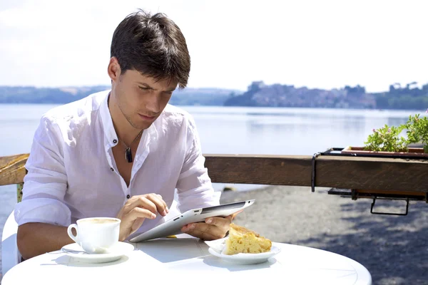 Seriöser gut aussehender Mann, der mit Tablette vor dem Lakeblet arbeitet — Stockfoto