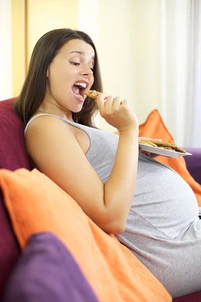 Беременная женщина ест приготовленный десерт счастливой — стоковое фото