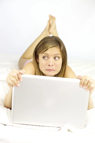 Blonde woman scared by computer — Stock Photo, Image