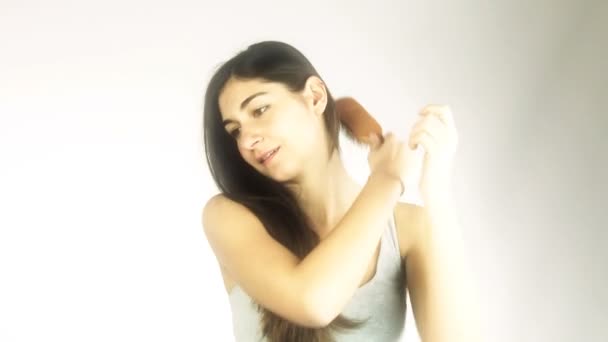 Donna felice pettinando i suoi lunghi capelli lucidi — Video Stock