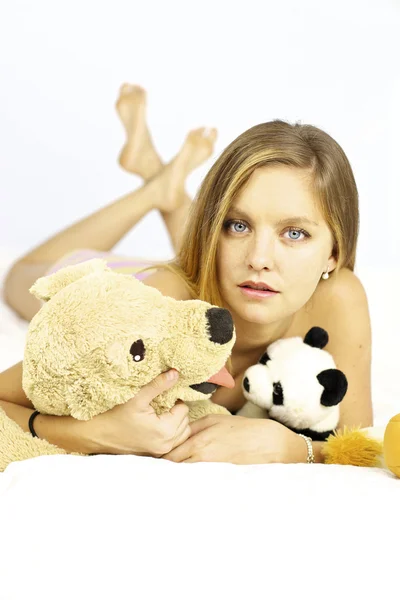 Beautiful blond female model with stuffed animals — Stock Photo, Image