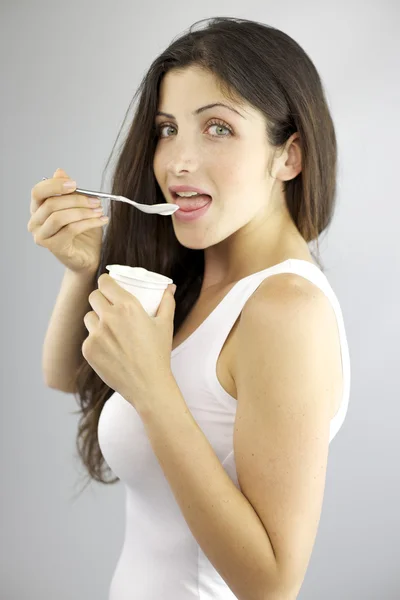 Feliz hermosa modelo femenina comiendo yogur blanco estando a dieta —  Fotos de Stock
