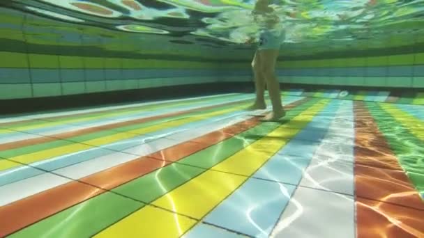 Kleiner Junge spaziert im Schwimmbad. — Stockvideo