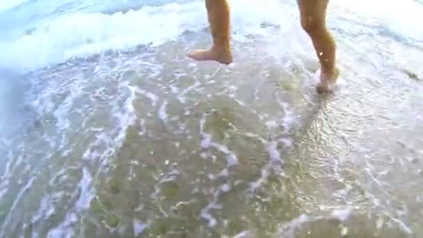 Море с песком и ногами ребенка из воды — стоковое видео